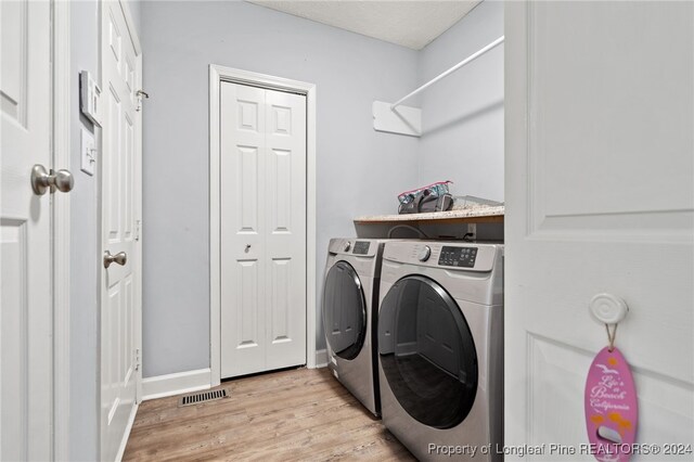 washroom featuring light wood-type flooring and washing machine and clothes dryer