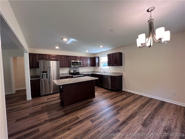 kitchen featuring sink, a center island, hanging light fixtures, stainless steel appliances, and dark wood-type flooring