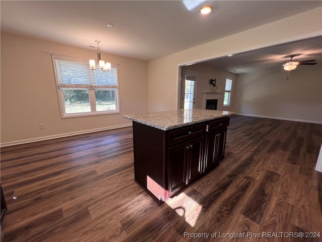 kitchen with a center island, decorative light fixtures, ceiling fan with notable chandelier, and dark hardwood / wood-style flooring