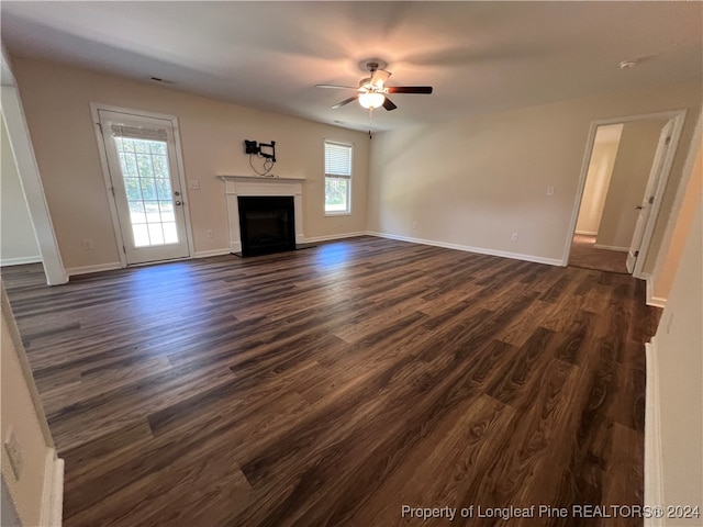 unfurnished living room with dark wood-type flooring and ceiling fan