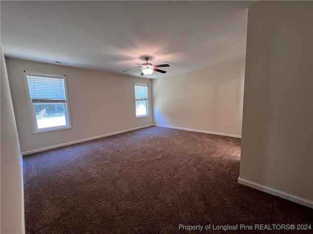 unfurnished room featuring dark carpet and ceiling fan