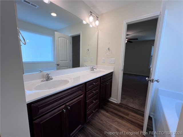 bathroom with vanity, wood-type flooring, a bath, and ceiling fan