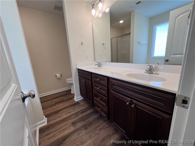 bathroom featuring toilet, walk in shower, vanity, and wood-type flooring