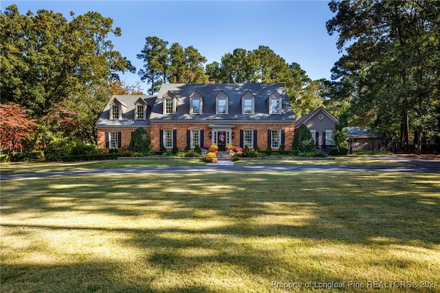 cape cod-style house with a front lawn