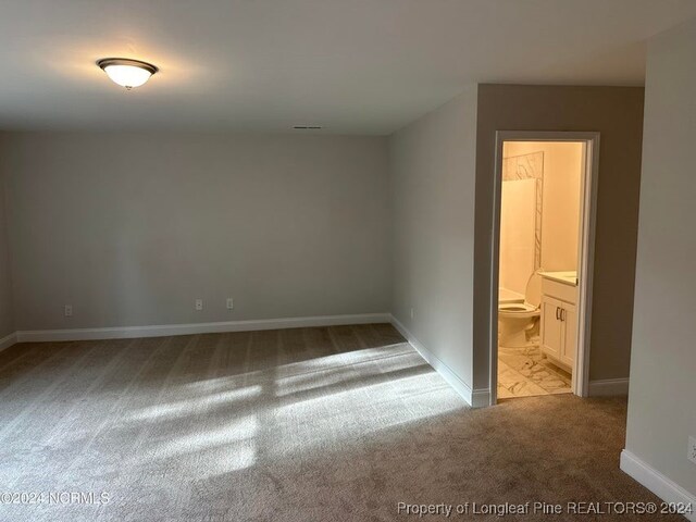 unfurnished bedroom with light carpet and ensuite bath