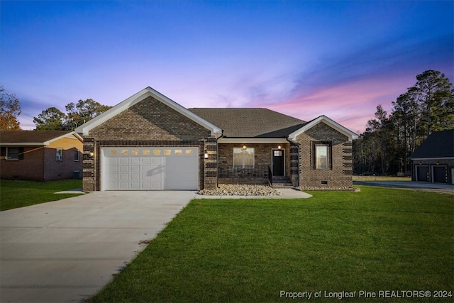 view of front of property with a garage and a yard