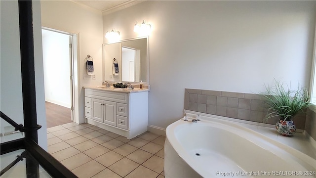 bathroom featuring crown molding, vanity, tile patterned floors, and a tub