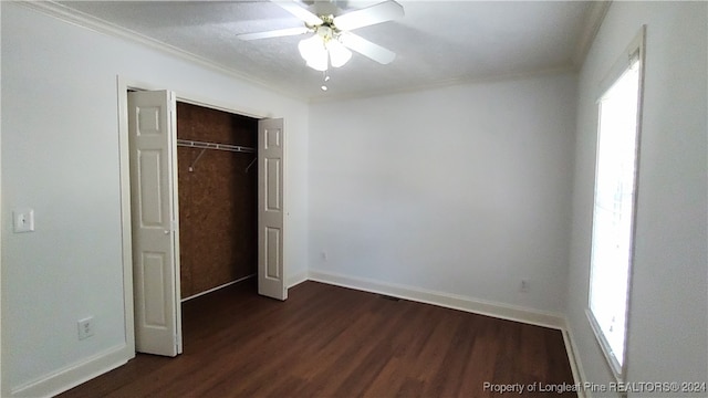 unfurnished bedroom featuring dark hardwood / wood-style flooring, a closet, ornamental molding, and ceiling fan