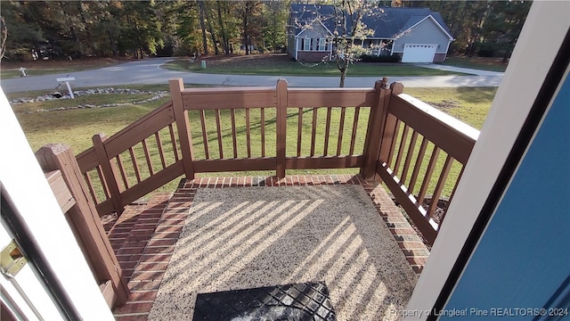 wooden terrace with a lawn, a porch, and a garage