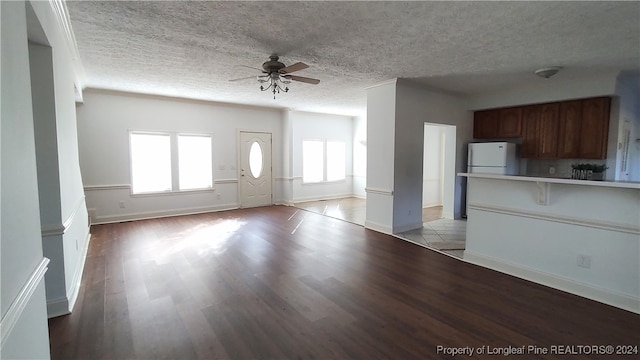 unfurnished living room featuring light hardwood / wood-style floors, a textured ceiling, and ceiling fan