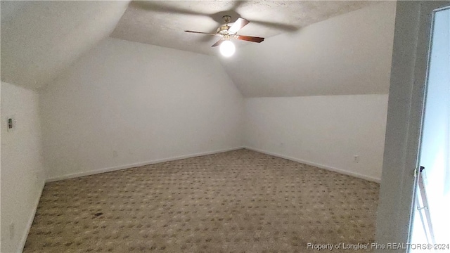 bonus room featuring ceiling fan, a textured ceiling, lofted ceiling, and carpet