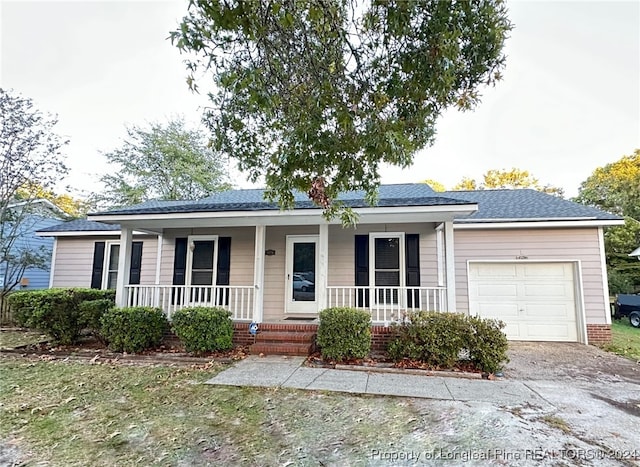 ranch-style house featuring a garage and covered porch