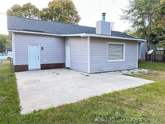 rear view of property featuring a patio and a lawn