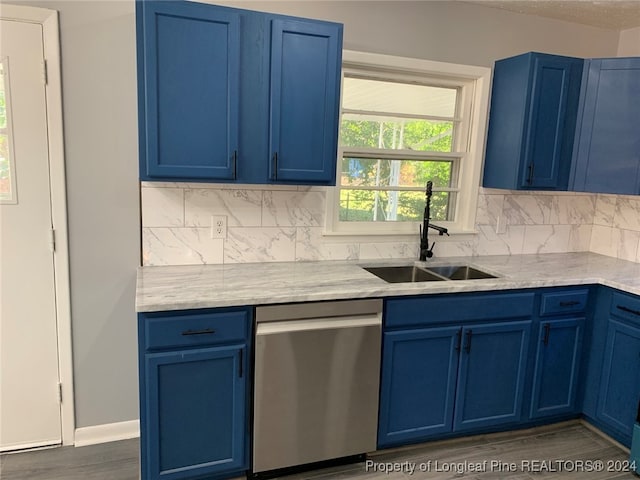 kitchen featuring blue cabinets, sink, tasteful backsplash, stainless steel dishwasher, and dark hardwood / wood-style floors