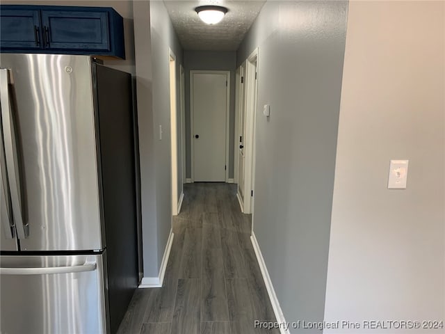 hallway featuring dark wood-type flooring and a textured ceiling