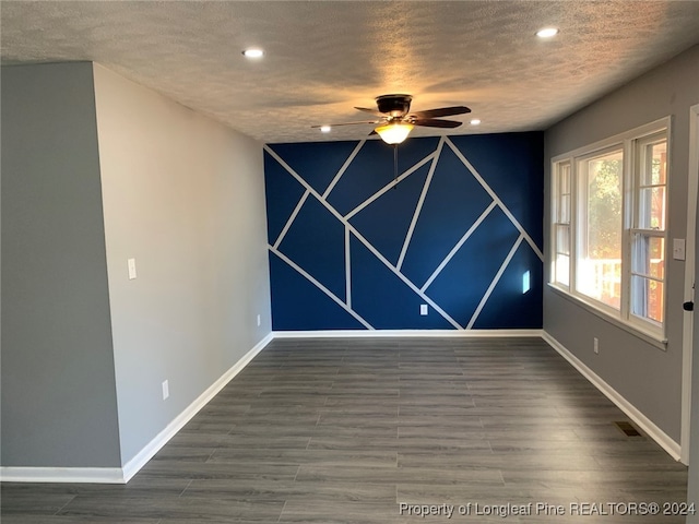 unfurnished room featuring dark hardwood / wood-style flooring, a textured ceiling, and ceiling fan