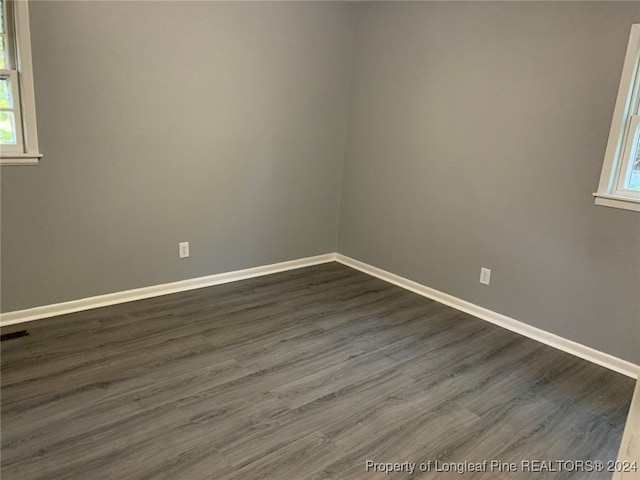 spare room with dark wood-type flooring