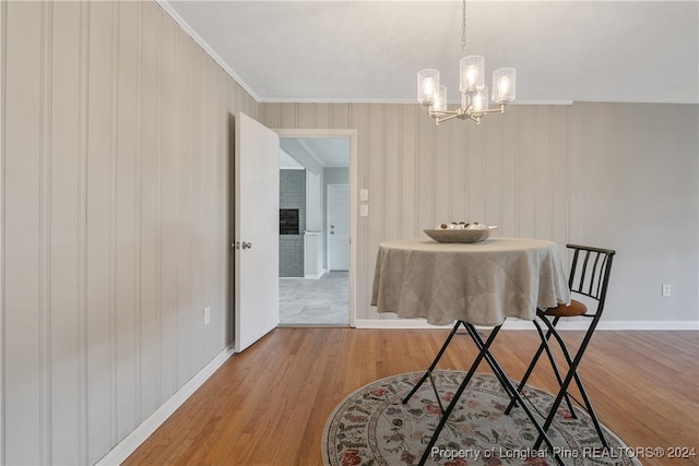 dining space featuring hardwood / wood-style floors, a notable chandelier, and crown molding