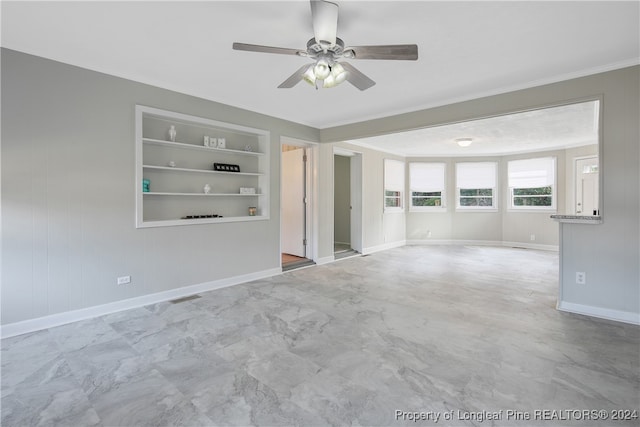 spare room featuring built in shelves, ceiling fan, and ornamental molding