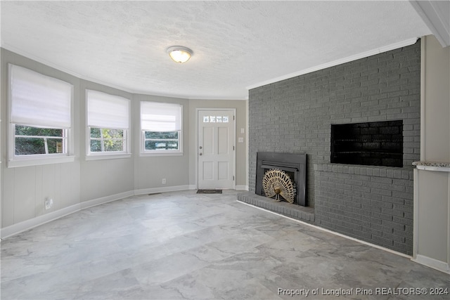 unfurnished living room featuring ornamental molding, a textured ceiling, and brick wall