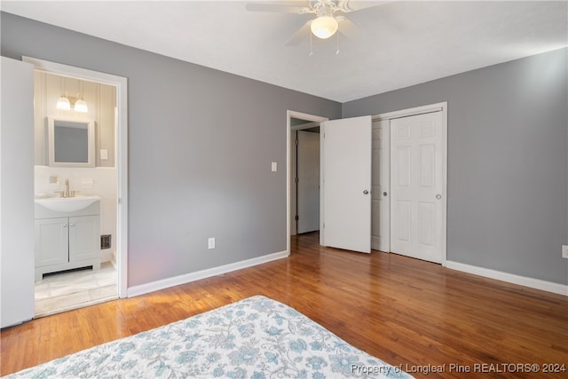 bedroom featuring hardwood / wood-style floors, sink, ceiling fan, connected bathroom, and a closet