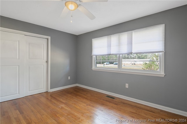 unfurnished bedroom featuring ceiling fan, light wood-type flooring, and a closet