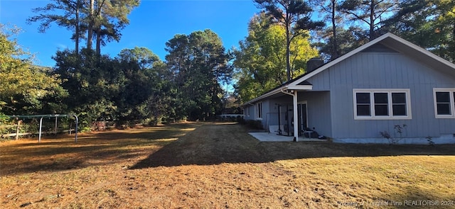 view of side of property featuring a playground and a lawn