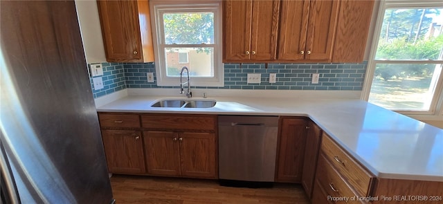 kitchen featuring dark hardwood / wood-style flooring, stainless steel appliances, backsplash, and sink