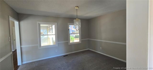 carpeted spare room with a textured ceiling