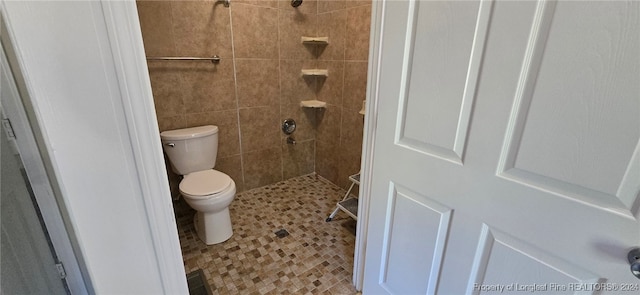 bathroom featuring toilet and a tile shower