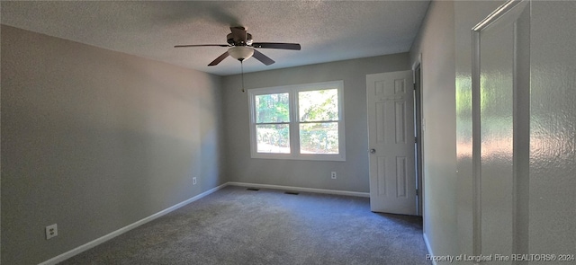 unfurnished room with carpet flooring, ceiling fan, and a textured ceiling