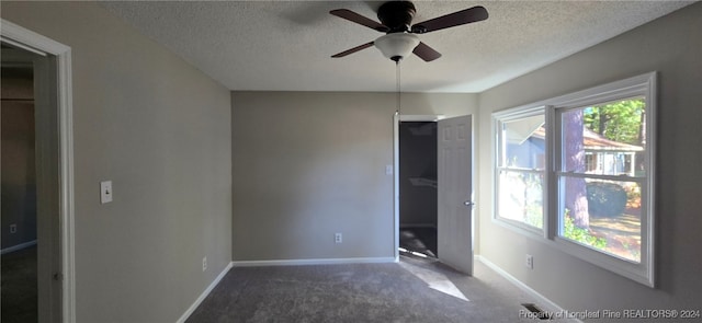 unfurnished bedroom with a textured ceiling, carpet floors, and ceiling fan