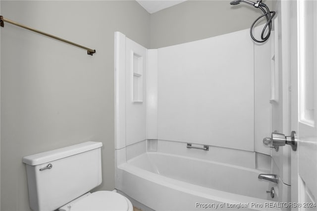 bathroom with bathing tub / shower combination and toilet