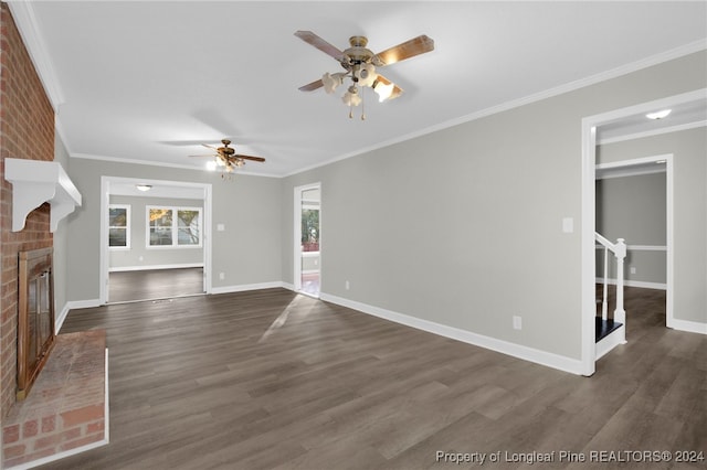 unfurnished living room with ceiling fan, dark hardwood / wood-style flooring, ornamental molding, and a brick fireplace