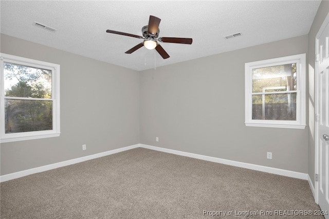 carpeted spare room featuring ceiling fan and a textured ceiling