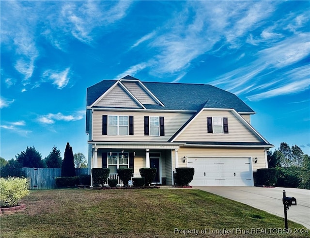 view of property featuring a front yard, a porch, and a garage