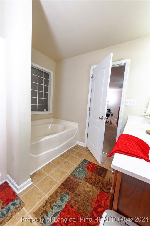 bathroom featuring vanity, tile patterned floors, and a tub