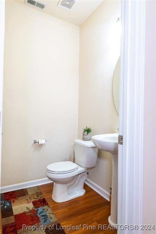 bathroom with hardwood / wood-style floors and toilet