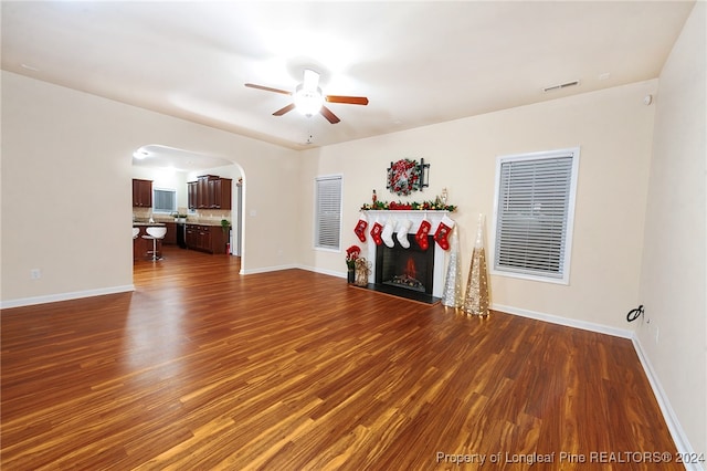 unfurnished living room featuring dark hardwood / wood-style floors and ceiling fan