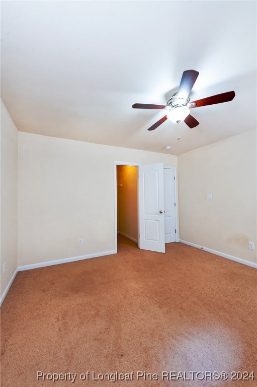 spare room featuring ceiling fan and carpet floors