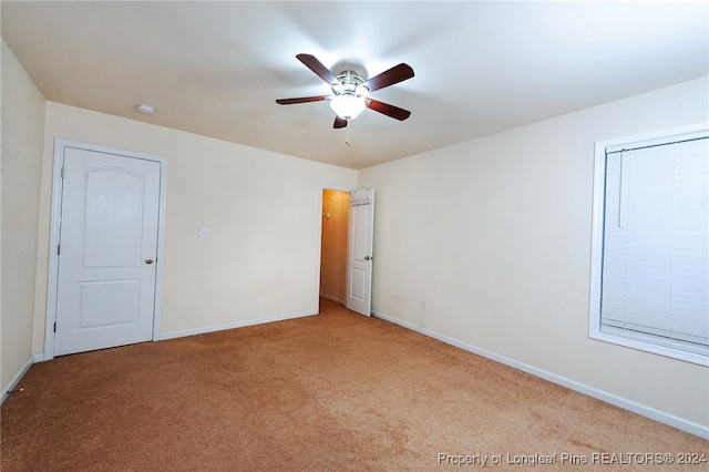 carpeted spare room featuring ceiling fan