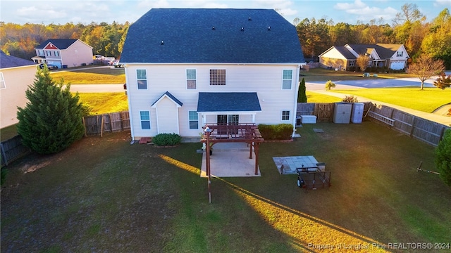 rear view of property with a patio, a storage unit, and a lawn