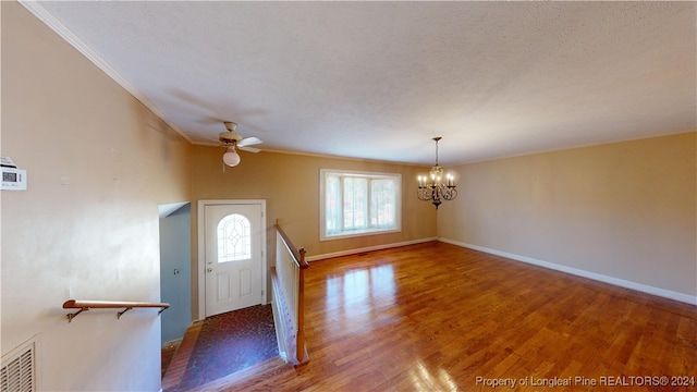 entrance foyer with ceiling fan with notable chandelier, a textured ceiling, hardwood / wood-style flooring, and crown molding