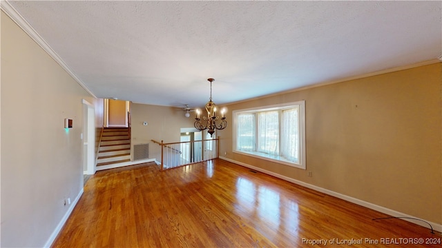 interior space with crown molding, hardwood / wood-style floors, a textured ceiling, and a notable chandelier