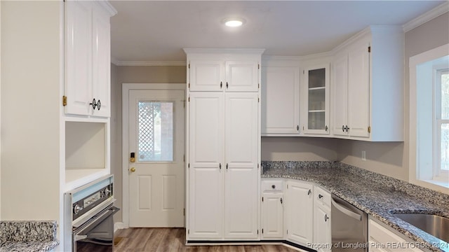 kitchen featuring white cabinets, a healthy amount of sunlight, ornamental molding, and appliances with stainless steel finishes