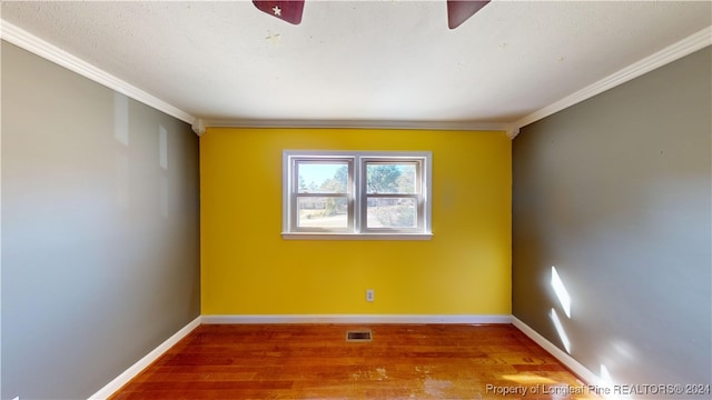 spare room featuring wood-type flooring and crown molding