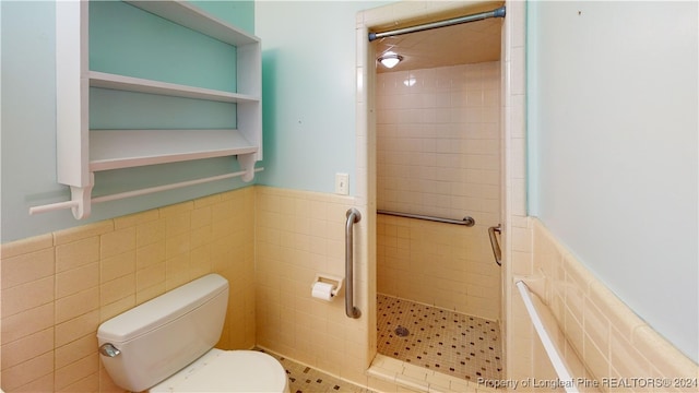 bathroom featuring a tile shower, tile patterned flooring, tile walls, and toilet