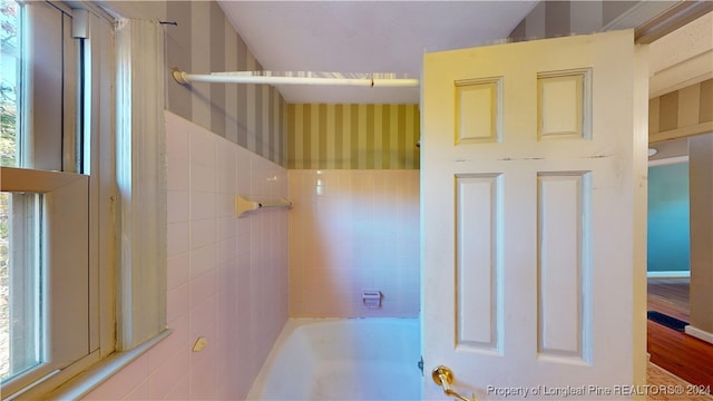 bathroom featuring tiled shower / bath combo and hardwood / wood-style flooring