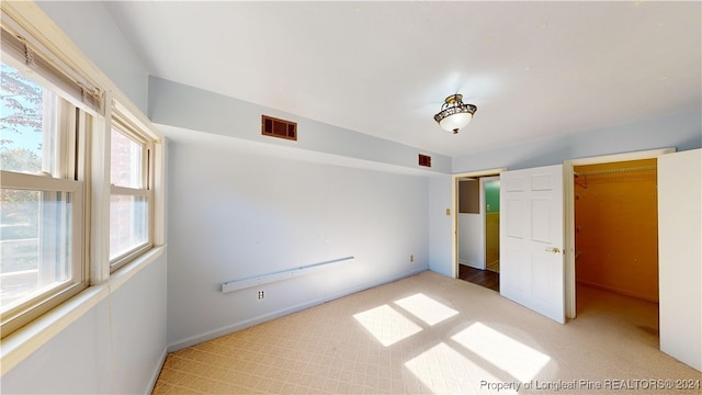 unfurnished bedroom featuring a closet and multiple windows