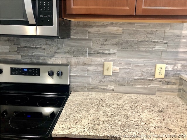 kitchen with stainless steel appliances and tasteful backsplash